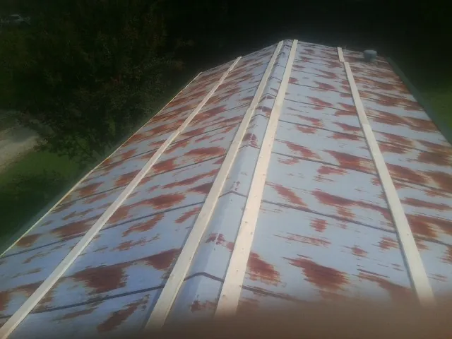 Rusted metal roof panels with new wood purlins before replacement — Storm Damage Roof Repair in Central Square by Roofing Brothers