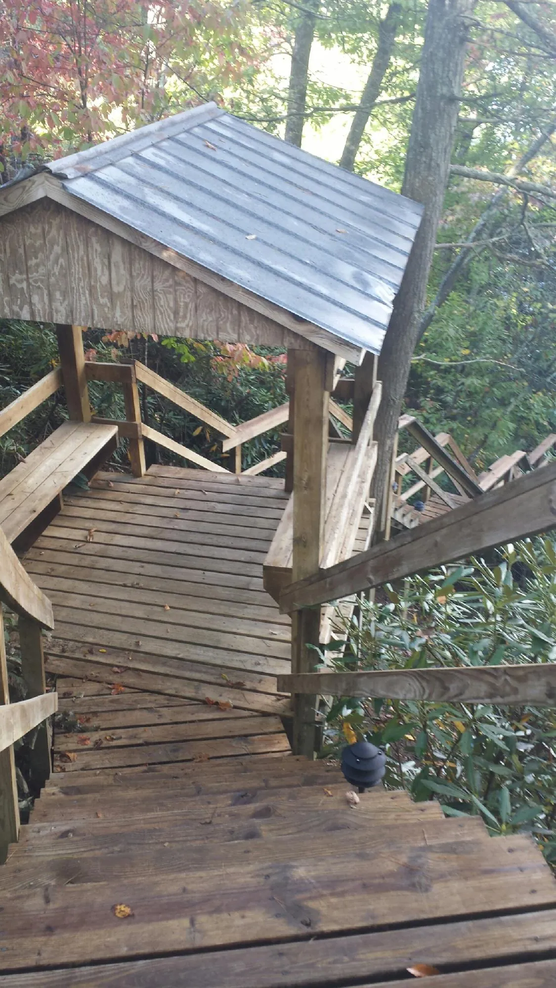 Metal roofed shelter over wooden steps on a wooded walkway — Skylight Repair & Installation work by our crew in Central Square