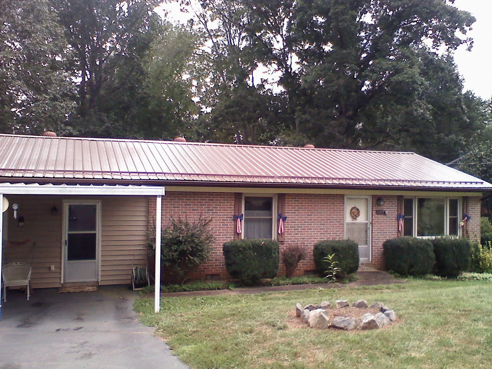 Bronze metal roof and carport on a brick ranch home — Roof Repair work by our crew in Central Square